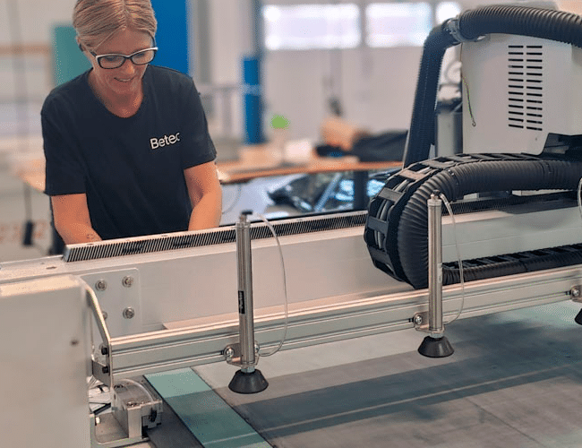 Maskinoperatør hos Betech klargør CNC-styret flatbed cutter til fremstilling af fladpakninger til industrikunde.